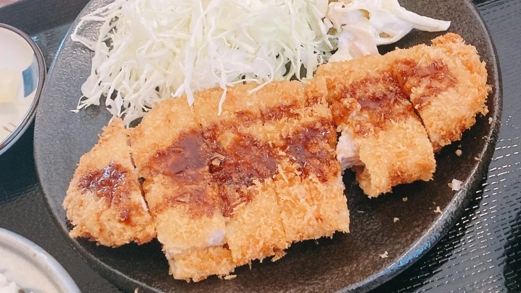 あづま家のとんかつにソースをかける